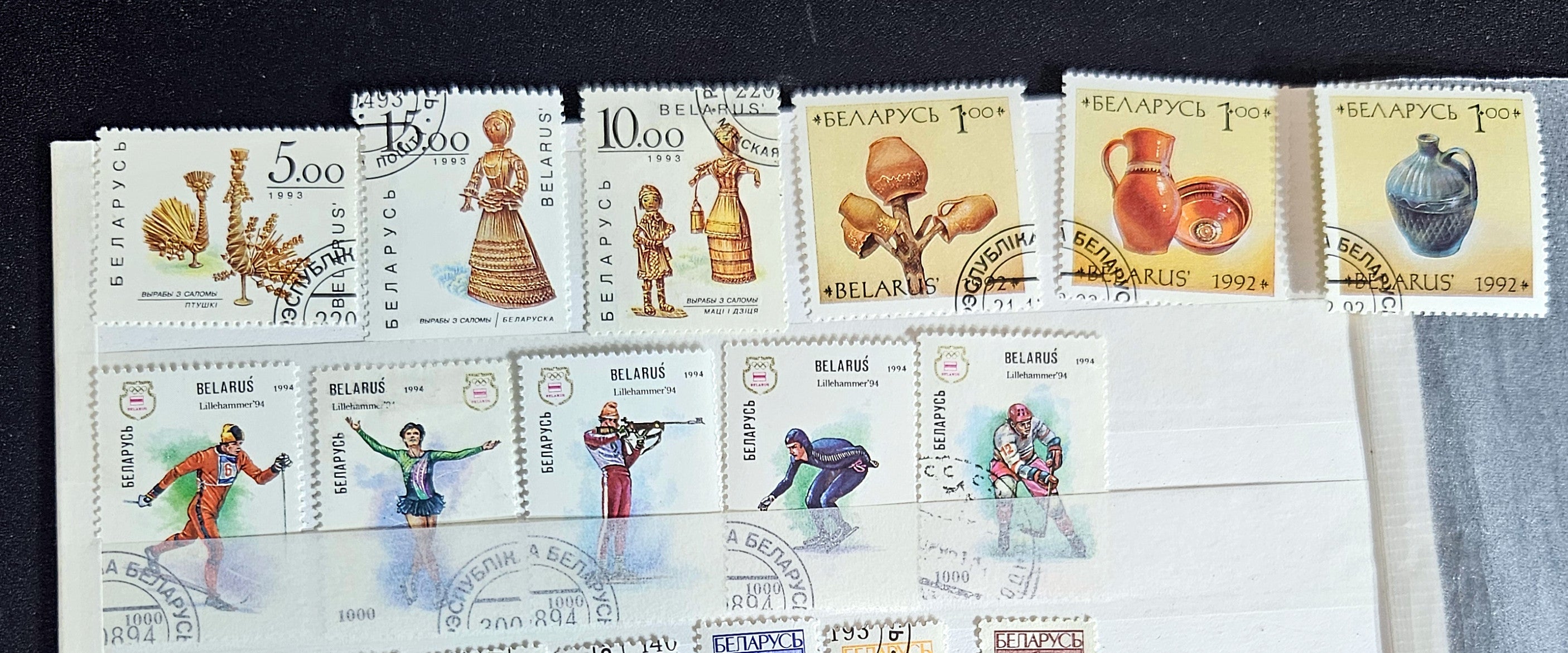 A collection of modern Belarusian stamps displayed in a row, featuring various designs including cultural figures and national symbols.