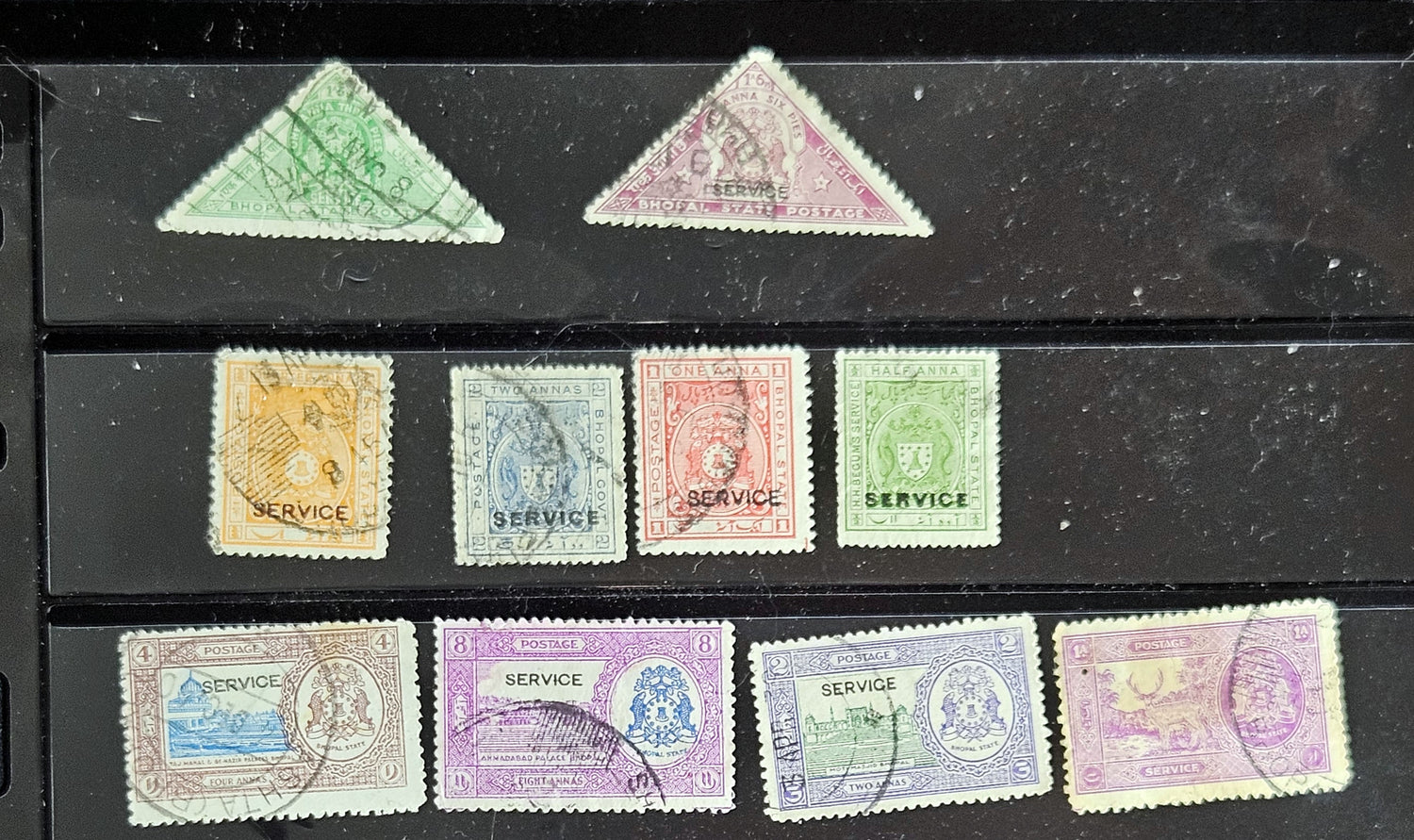 A collection of vintage Indian stamps from various feudatory states including Jhind, Bhopal, Saurashtra, Hyderabad, and Holkar, displayed on a flat surface.