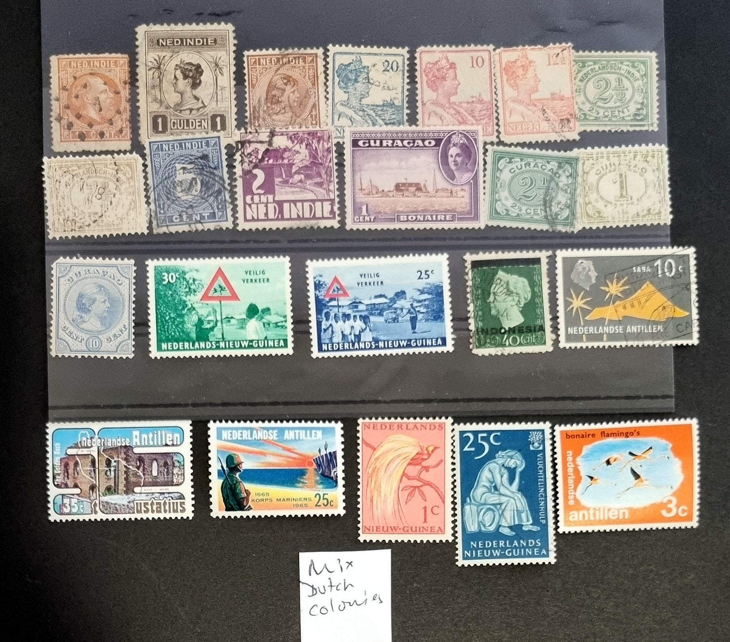 A collection of vintage postage stamps from the Netherlands colonies, featuring various designs and denominations.