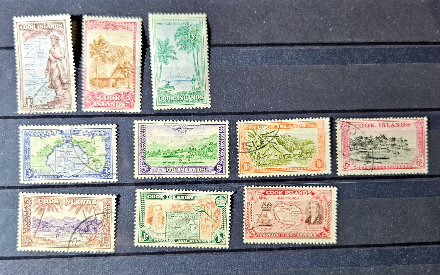 Collection of vintage stamps from Cook Islands on a dark surface