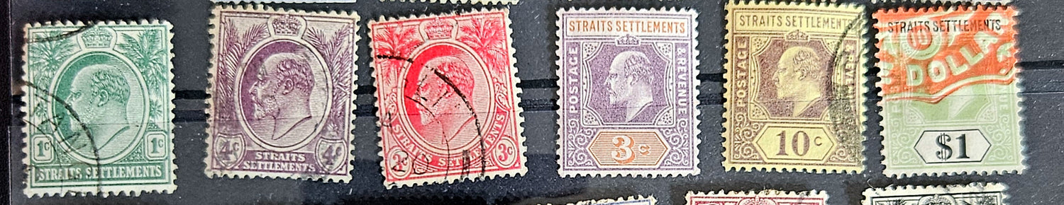 A collection of vintage postage stamps from the Straits Settlements, featuring various colors and designs, displayed on a flat surface.