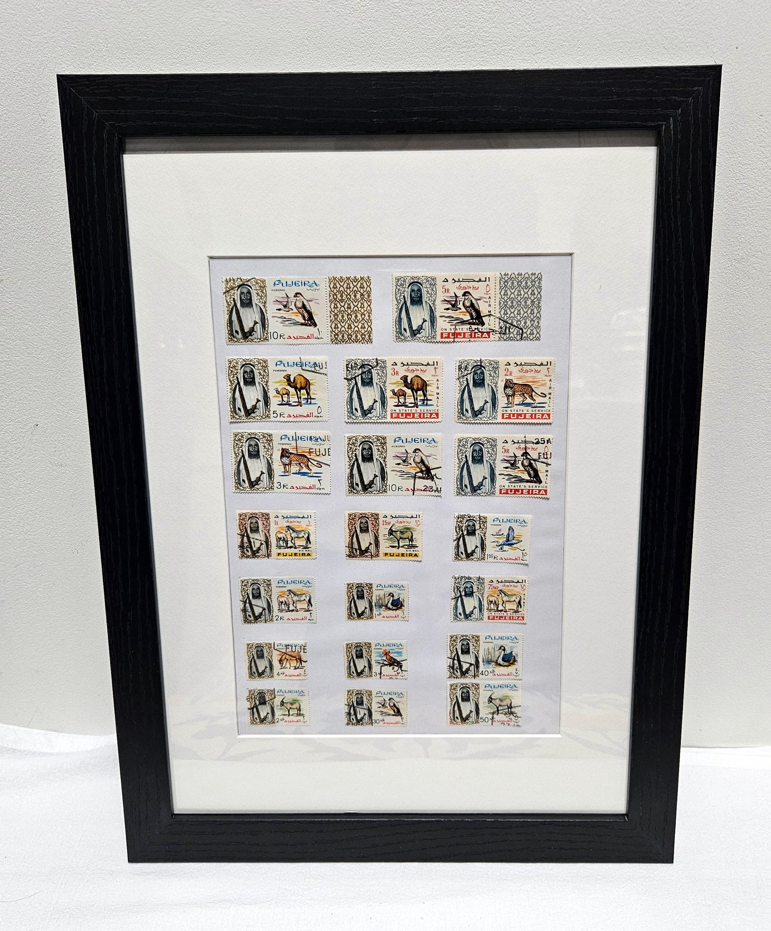 Framed collection of Fujairah vintage stamps with black frame