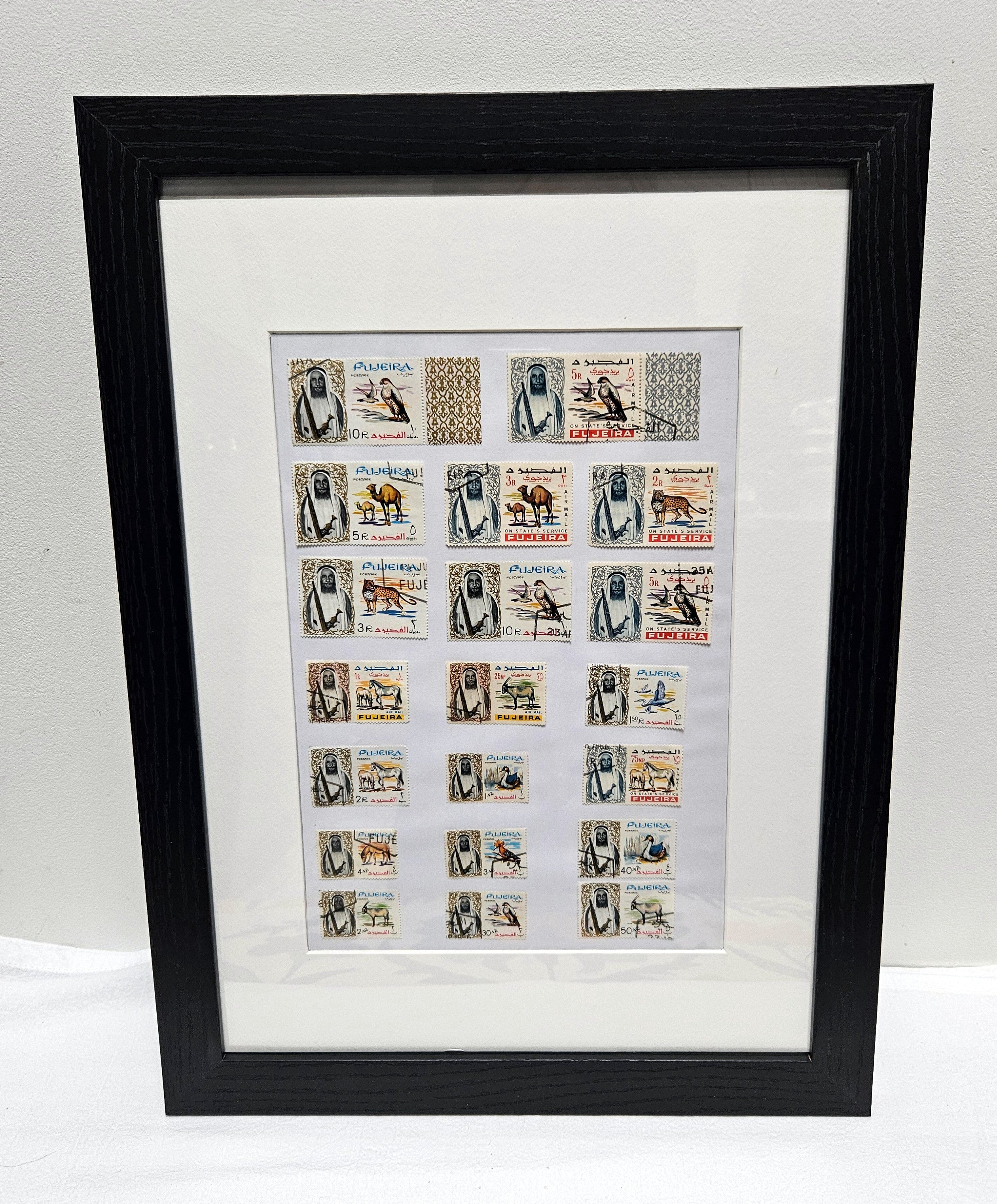 Framed collection of Fujairah vintage stamps with black frame