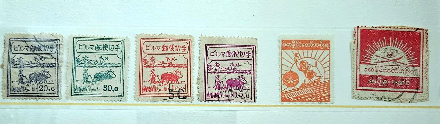 Six vintage Japanese postage stamps in different colors (blue-gray, green, orange, purple, red-orange, and red) lined up horizontally on a white background.