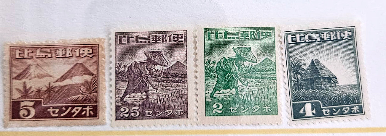 Four vintage Japanese postage stamps displayed side by side on a white background. The stamps are brown, dark gray-brown, green, and olive green, featuring illustrations of mountains, a farmer, a worker, and a hut, with denominations of 5, 2.