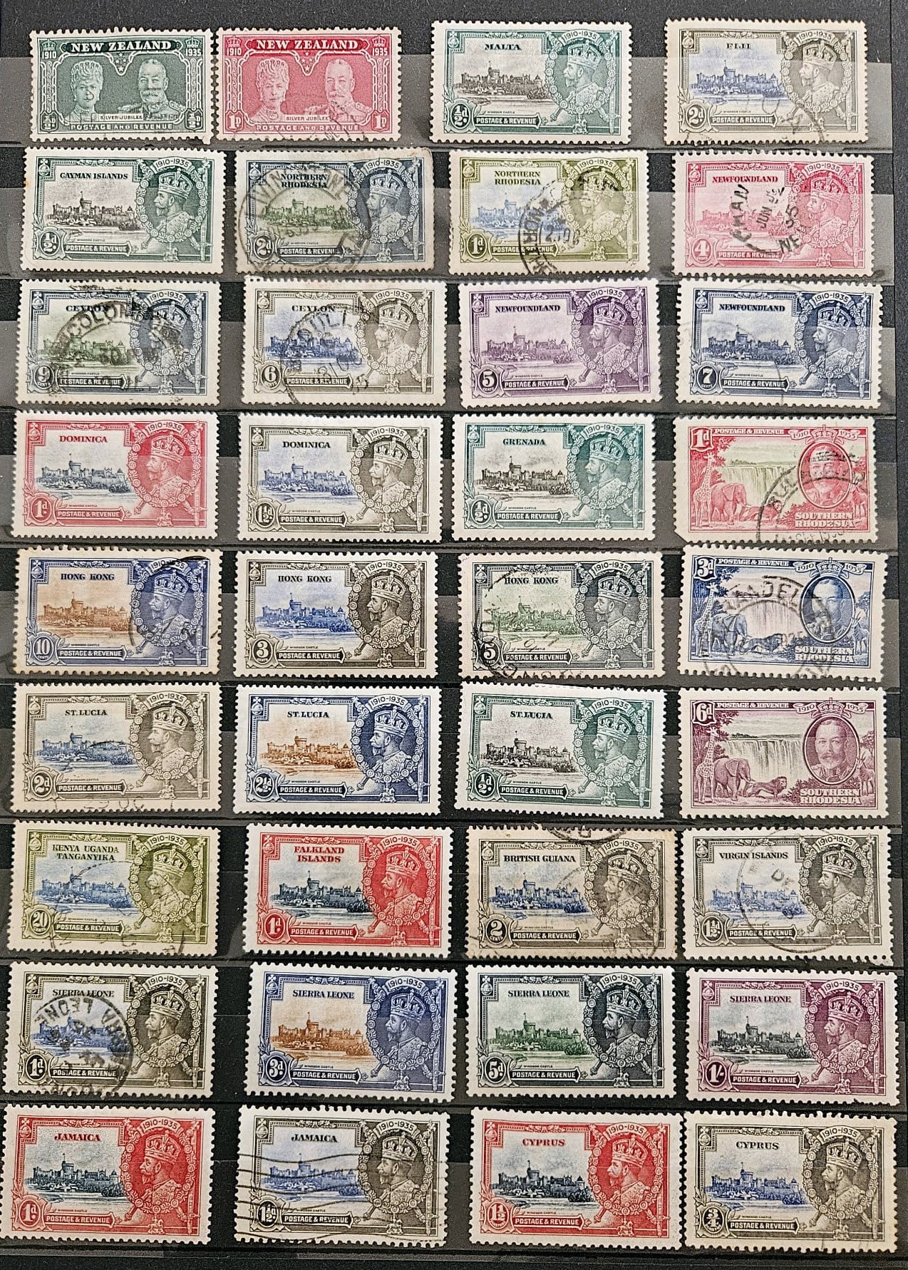 A collection of vintage postage stamps arranged in a grid on a dark background. The stamps feature various colors including red, blue, green, purple, and brown, with some showing postmarks and cancellations.