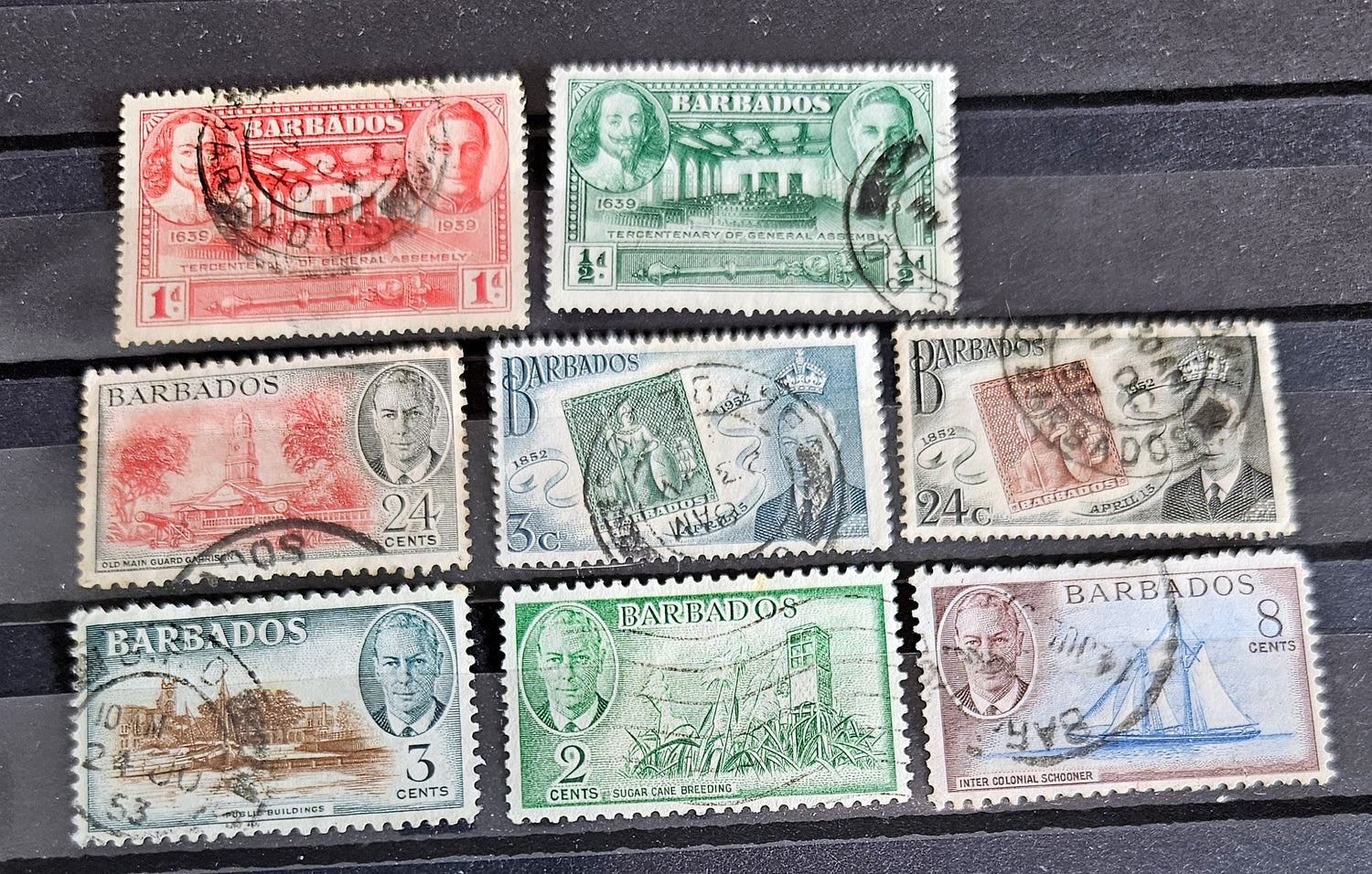 A set of vintage postage stamps from the British Commonwealth, featuring various designs and denominations, arranged in a row.