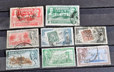 A set of vintage postage stamps from the British Commonwealth, featuring various designs and denominations, arranged in a row.