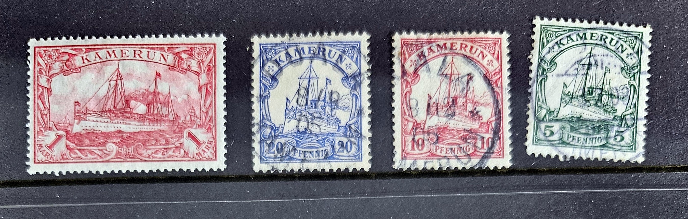 A set of vintage German colonies postage stamps, featuring various designs and colors, predominantly in shades of red and green.