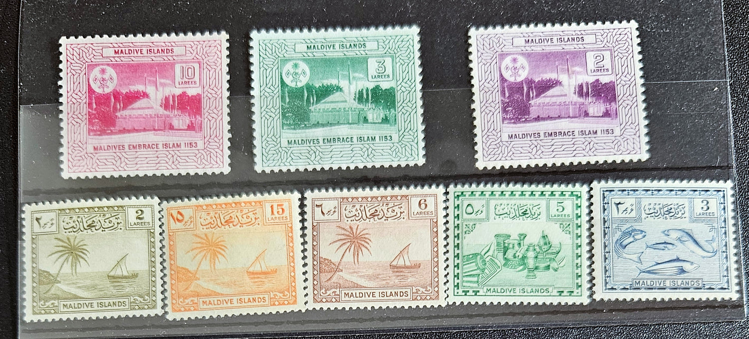 A collection of vintage postage stamps from Maldives Islands, featuring various designs and denominations, displayed on a dark background.