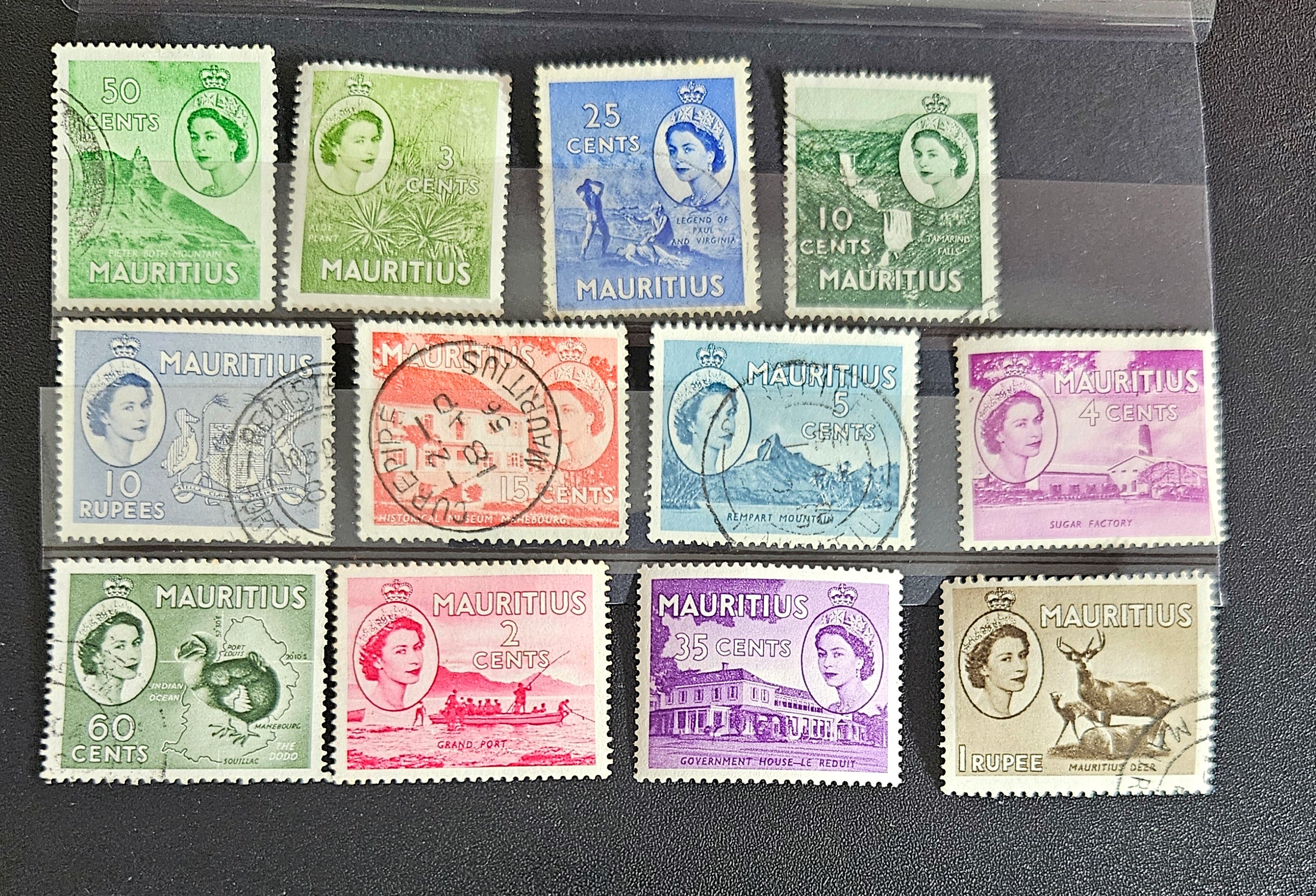 A collection of vintage postage stamps from Mauritius displayed in a row, featuring various designs and denominations.