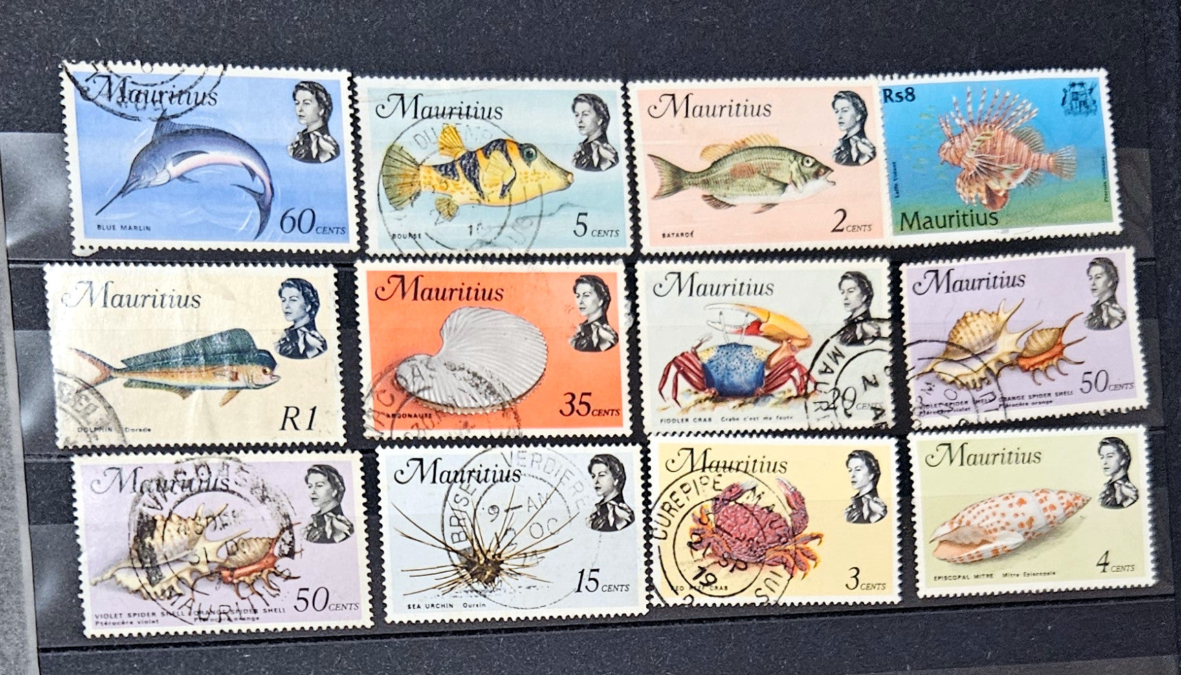 A collection of vintage postage stamps from Mauritius displayed in a row, featuring various designs and denominations.