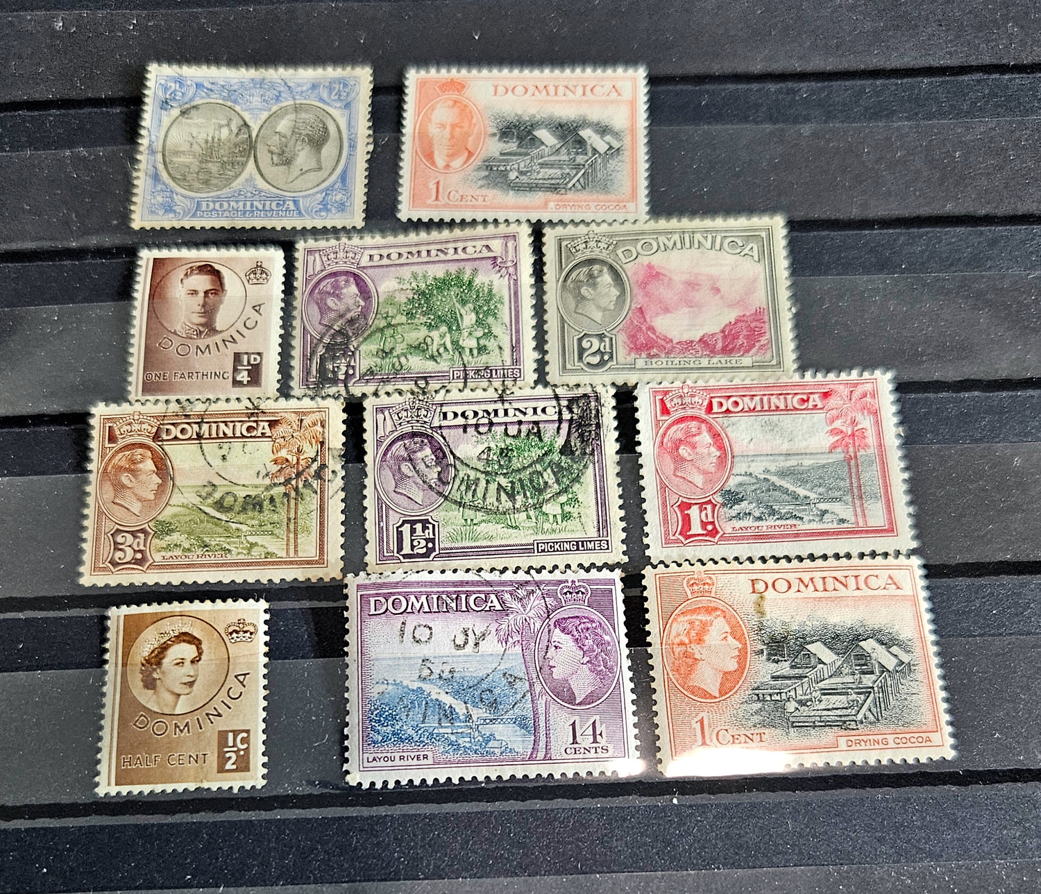 Collection of vintage Dominica stamps on a wooden surface