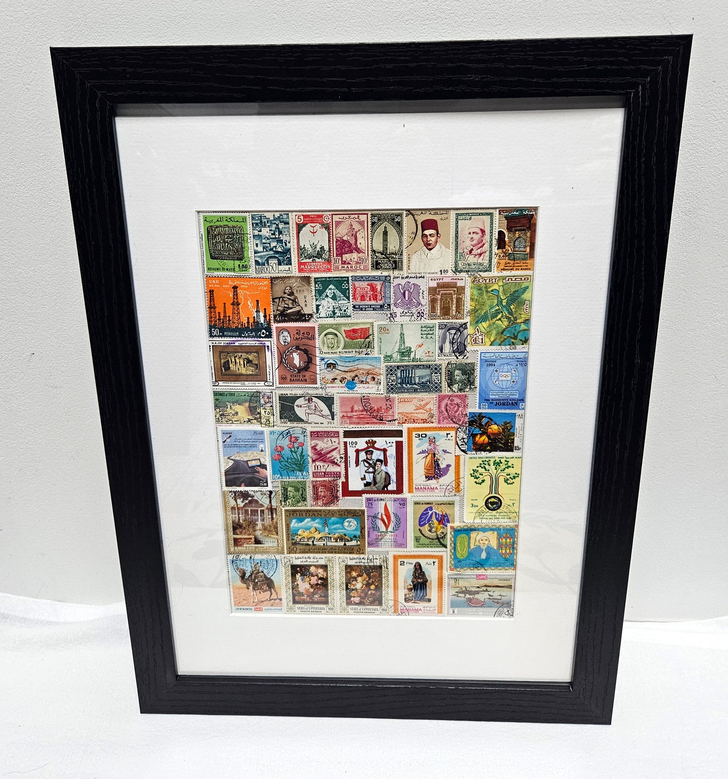 Framed collage of various Arab postage stamps with a black frame.