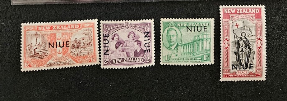 Four vintage stamps from New Zealand and Niue on a black background