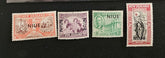 Four vintage stamps from New Zealand and Niue on a black background