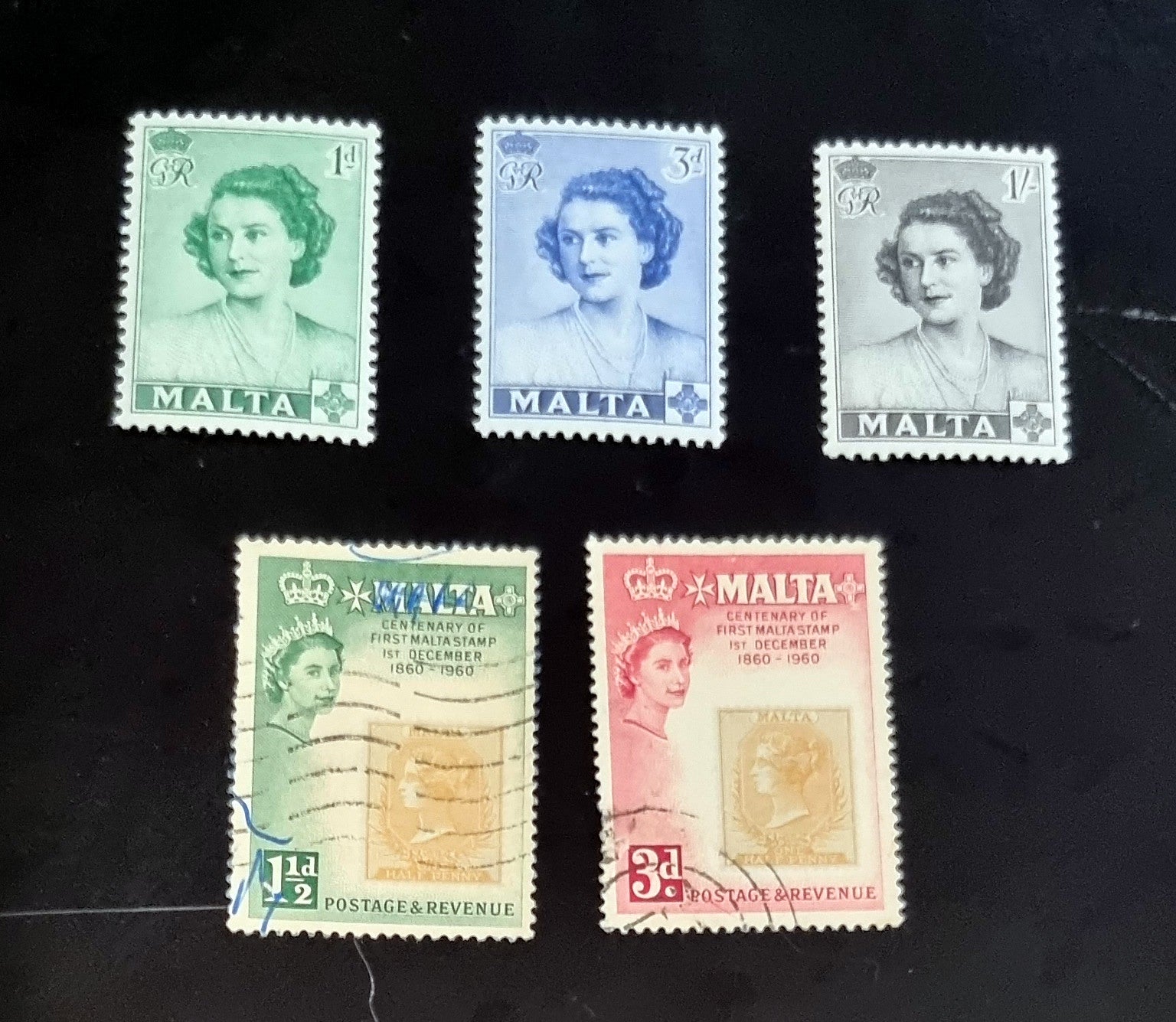 A collection of vintage postage stamps from Malta featuring various designs and colors, arranged in no specific order on a surface.