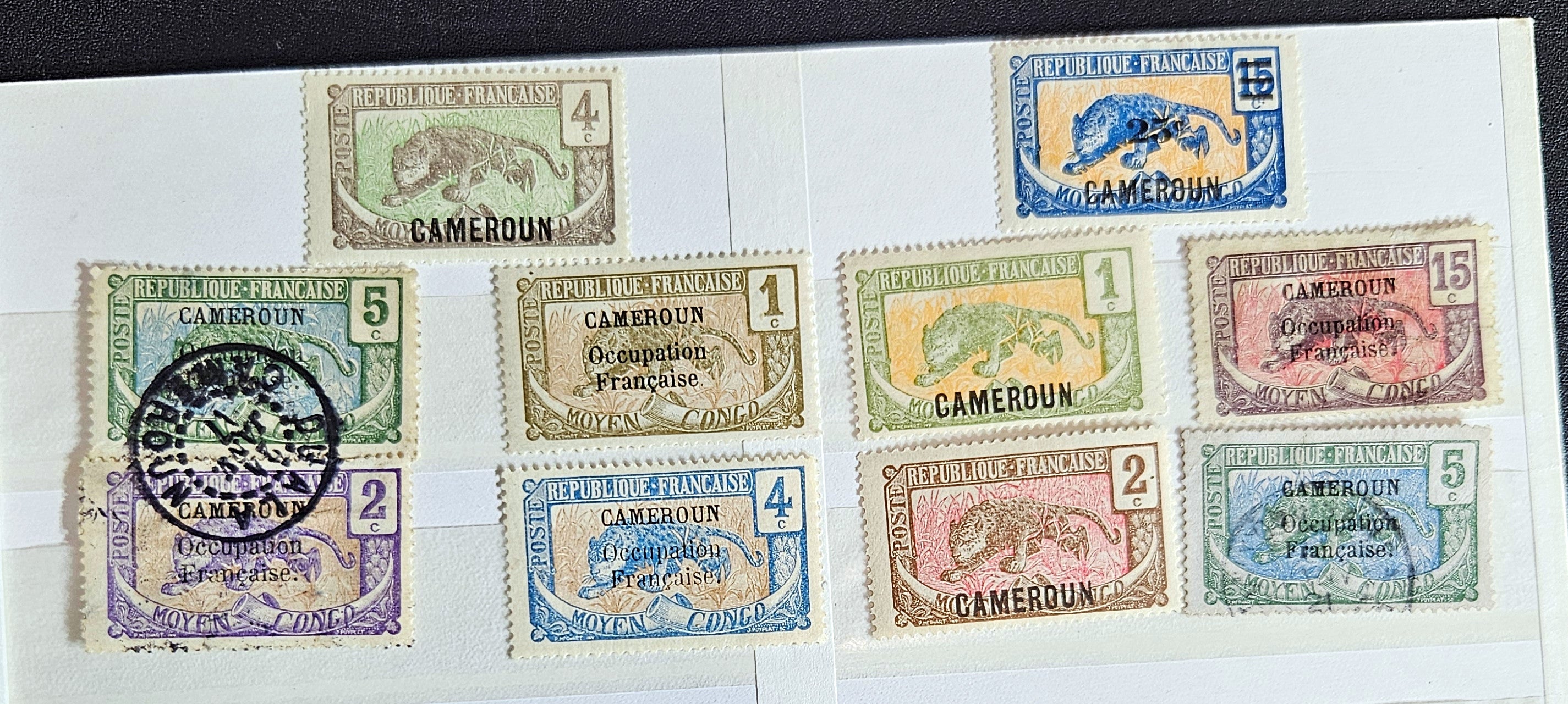 A collection of vintage French Cameroon stamps displayed on a surface, featuring various colors and designs.