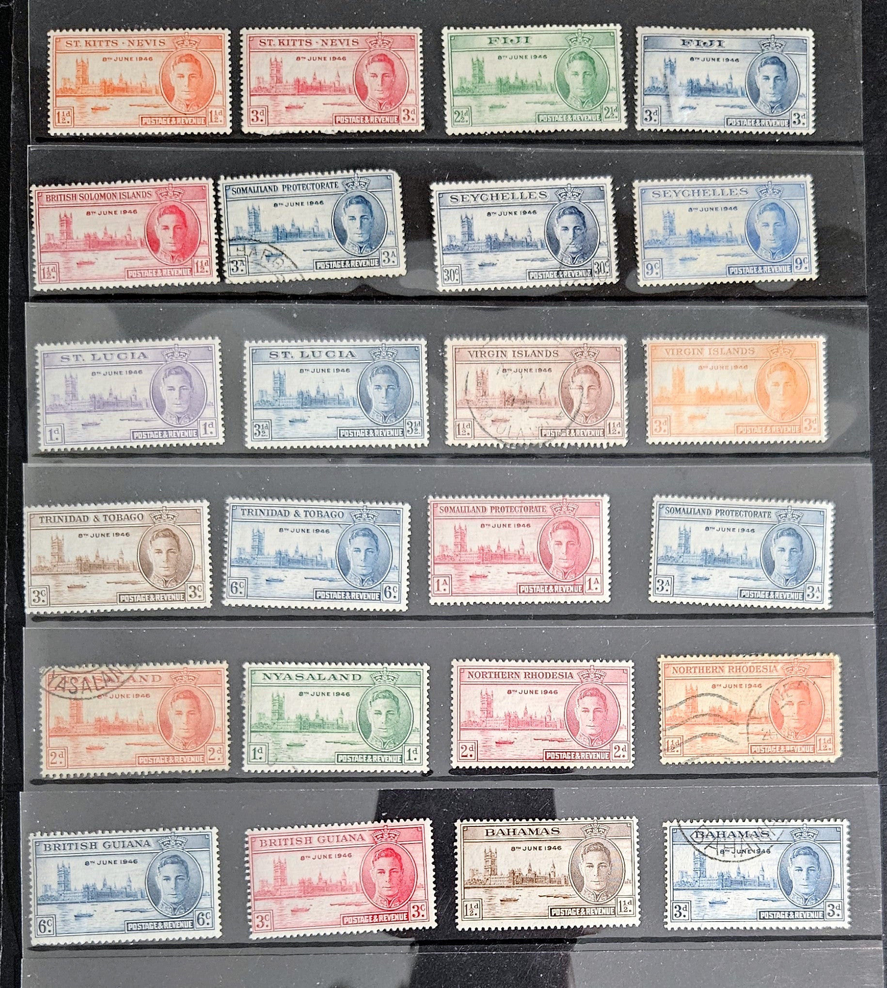 An assortment of vintage postage stamps featuring King George VI, with various colors and designs, displayed in a row.