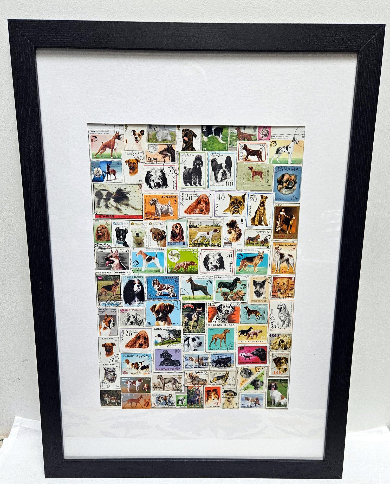Framed collage of various dog stamps on a white background