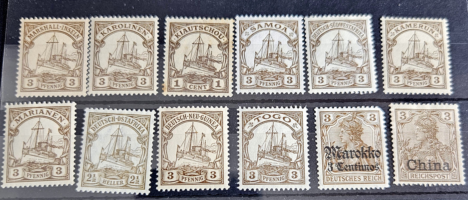 A collection of vintage postage stamps from various German colonies, featuring different colors and designs, arranged in a row on a white background.