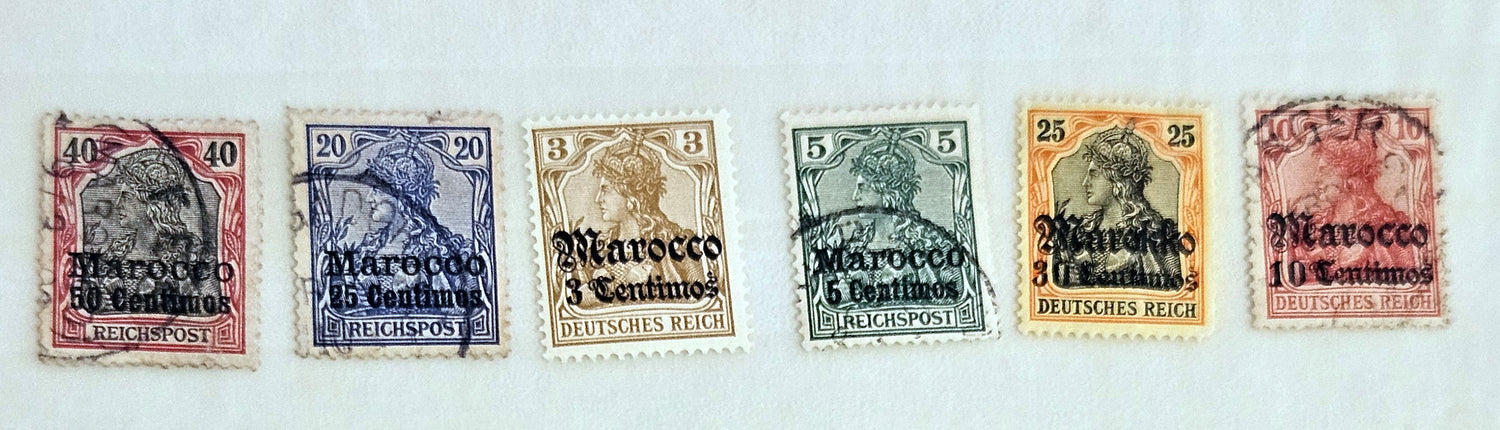 A collection of vintage postage stamps from various German colonies, featuring different colors and designs, arranged in a row on a white background.