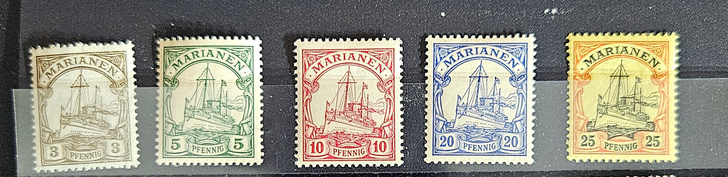 A collection of vintage postage stamps from various German colonies, featuring different colors and designs, arranged in a row on a white background.