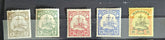 A collection of vintage postage stamps from various German colonies, featuring different colors and designs, arranged in a row on a white background.