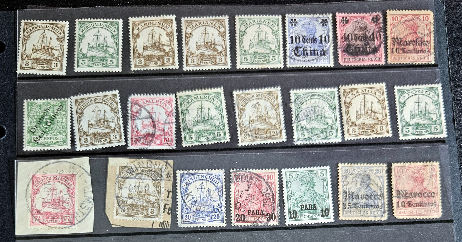 A collection of vintage postage stamps from various German colonies, featuring different colors and designs, arranged in a row on a white background.