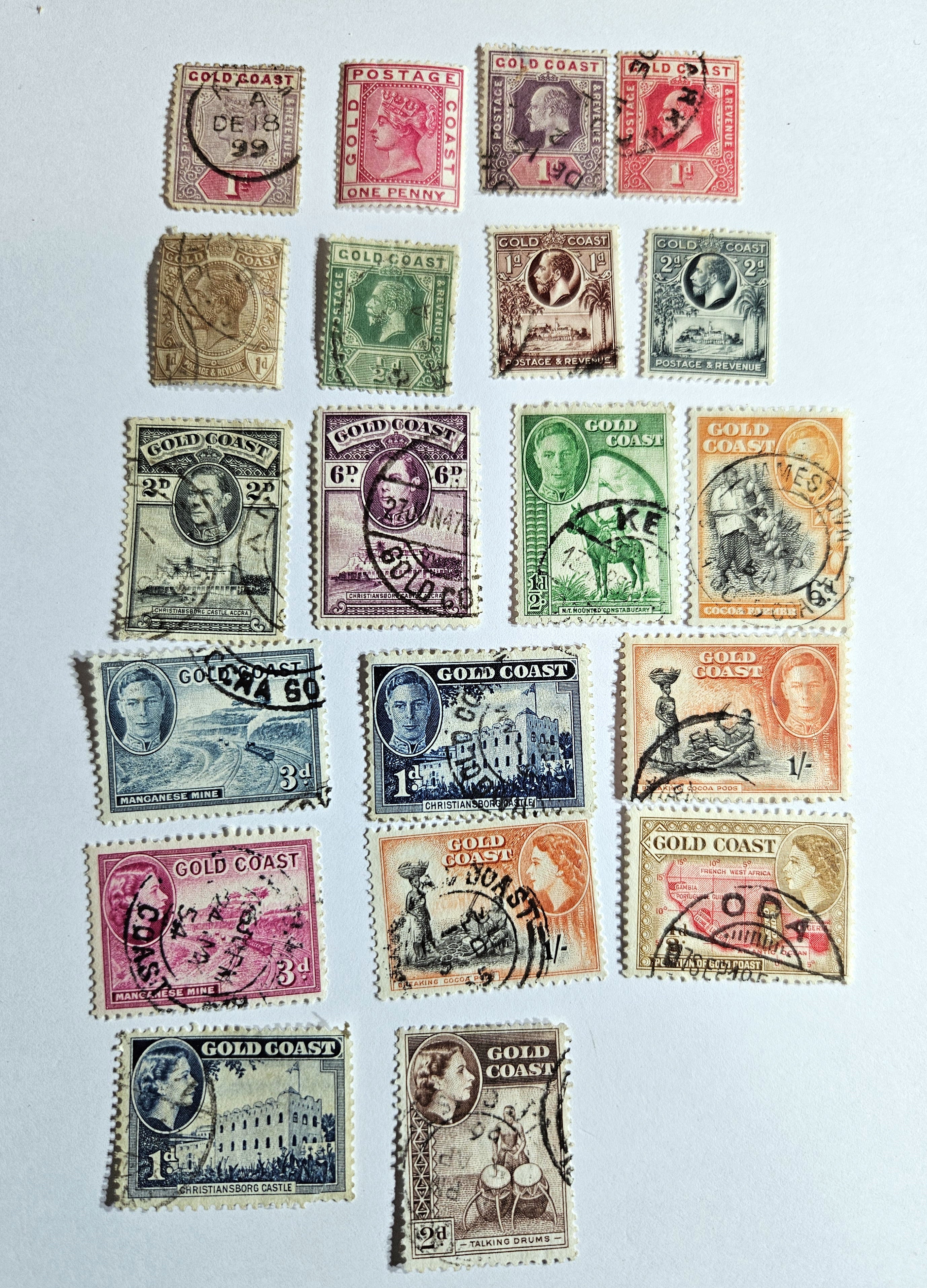 A collection of vintage Gold Coast stamps from the British Commonwealth, featuring various colors and designs, including portraits and geometric patterns.