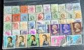 A collection of vintage Hong Kong stamps from various queens to post-handover issues, displayed on a surface.