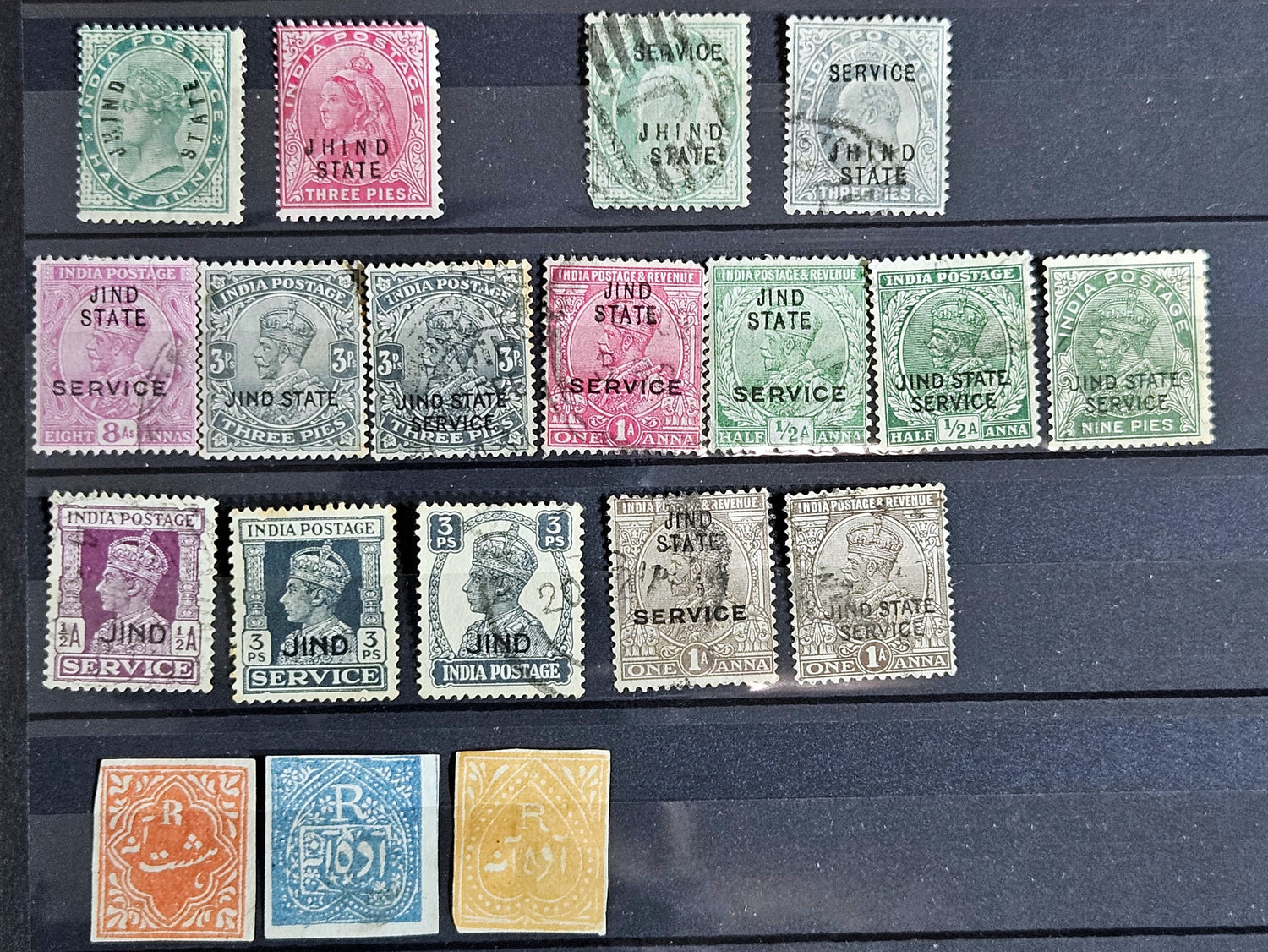 A collection of vintage Indian stamps from various feudatory states including Jhind, Bhopal, Saurashtra, Hyderabad, and Holkar, displayed on a flat surface.