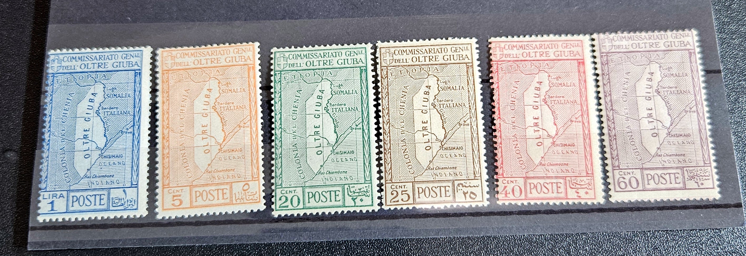 A set of vintage postage stamps from OLTRE GIUBA JUBALAND in various colors displayed on a flat surface.