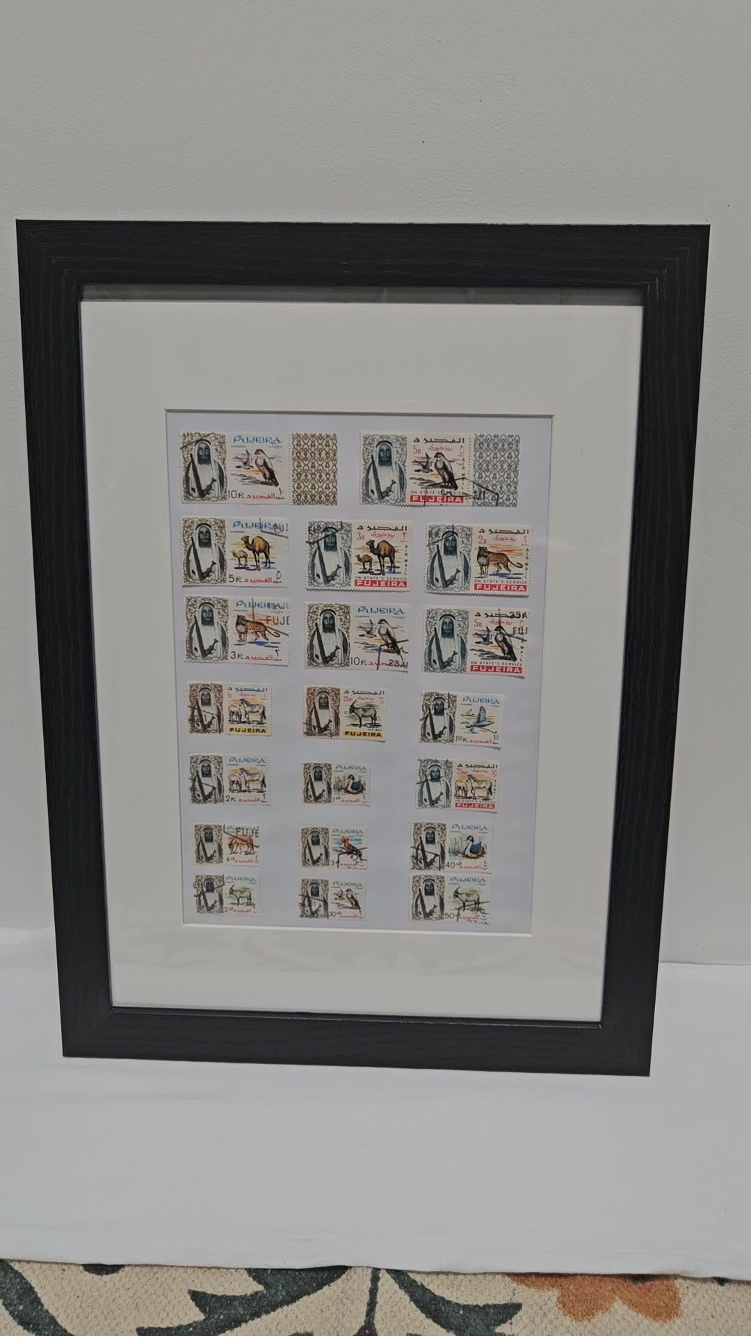 Framed collection of Fujairah vintage stamps with black frame