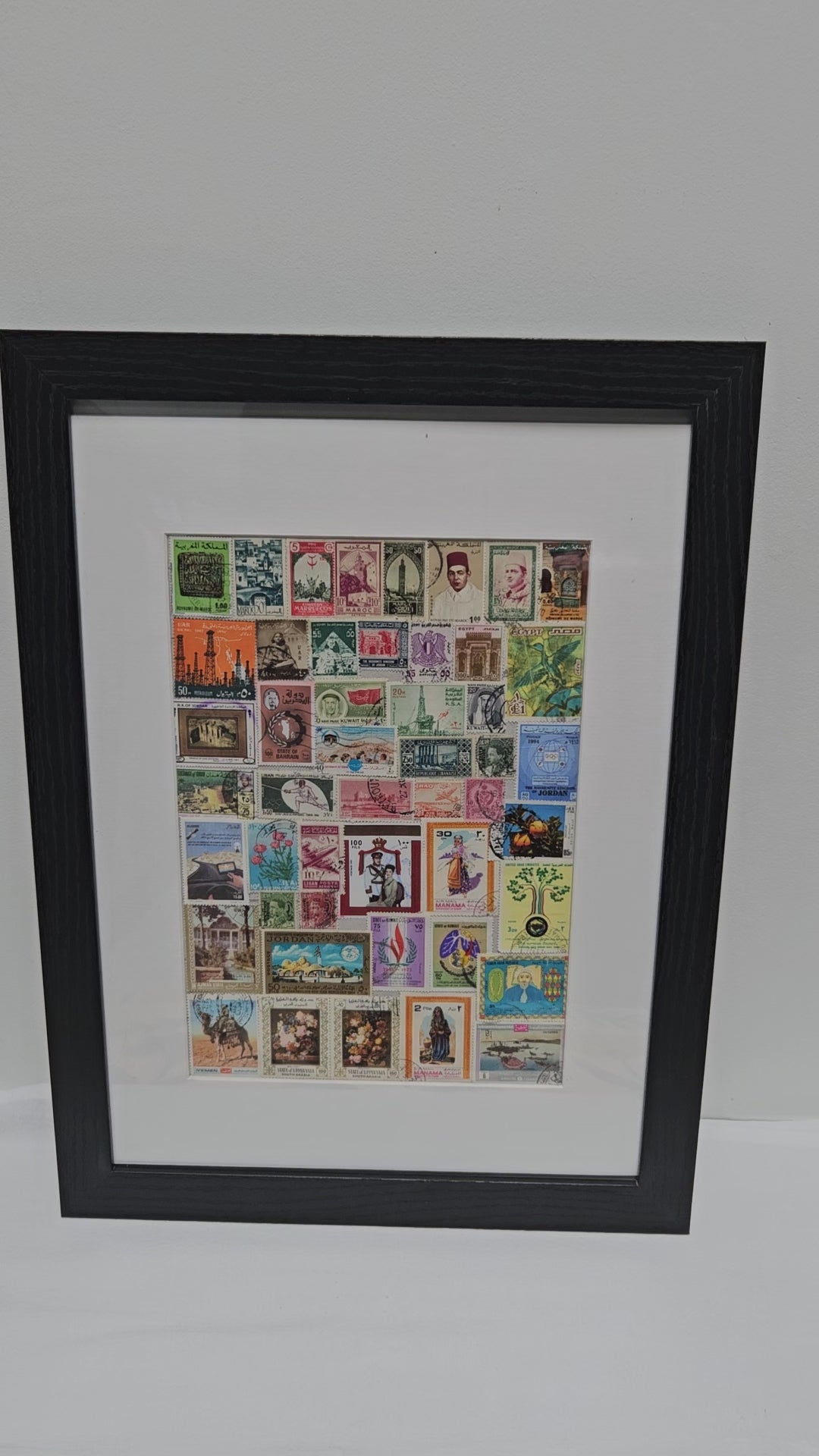 Framed collage of various Arab postage stamps with a black frame.