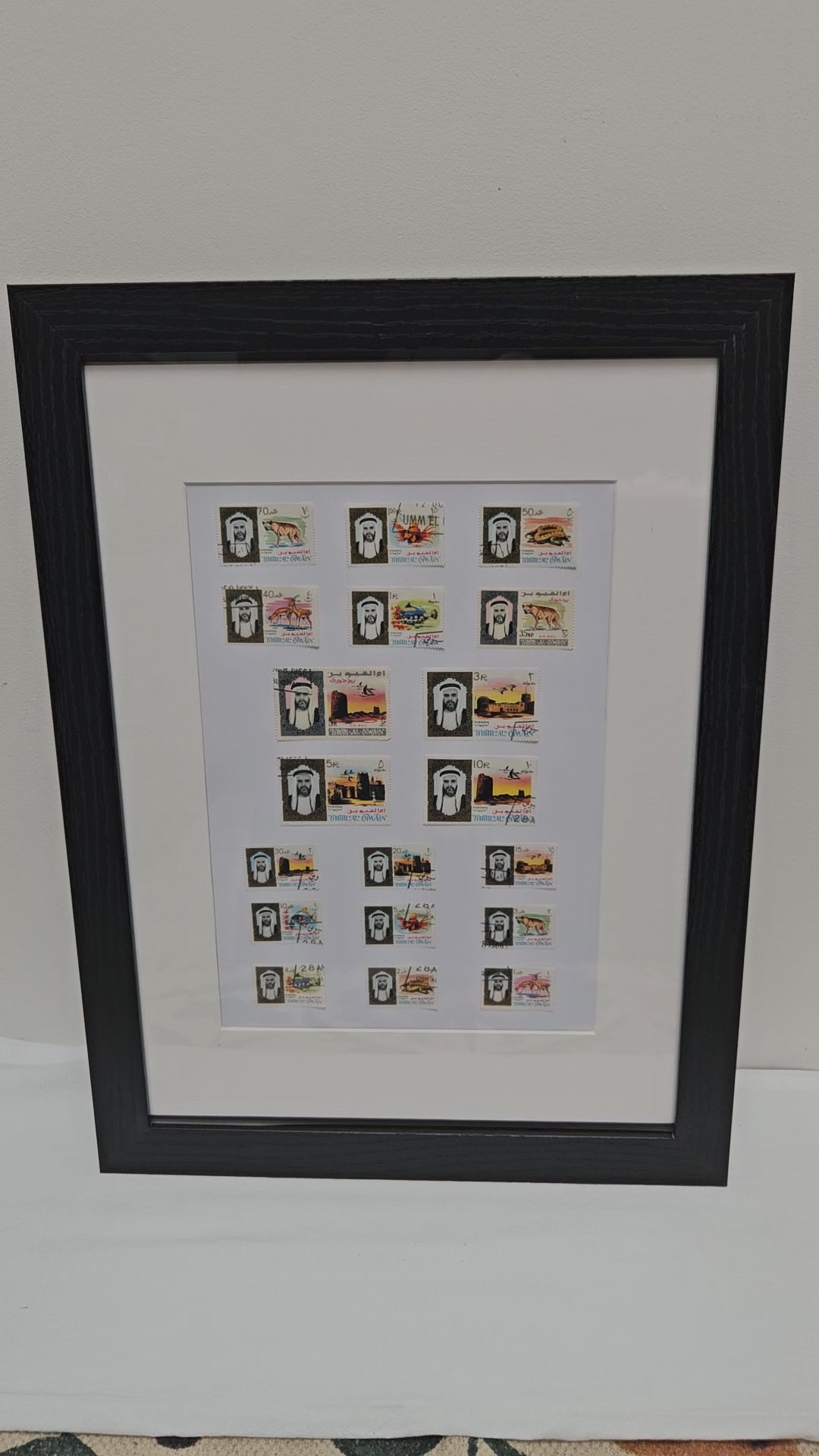 Framed collection of Umm Al Quwain stamps on a white background