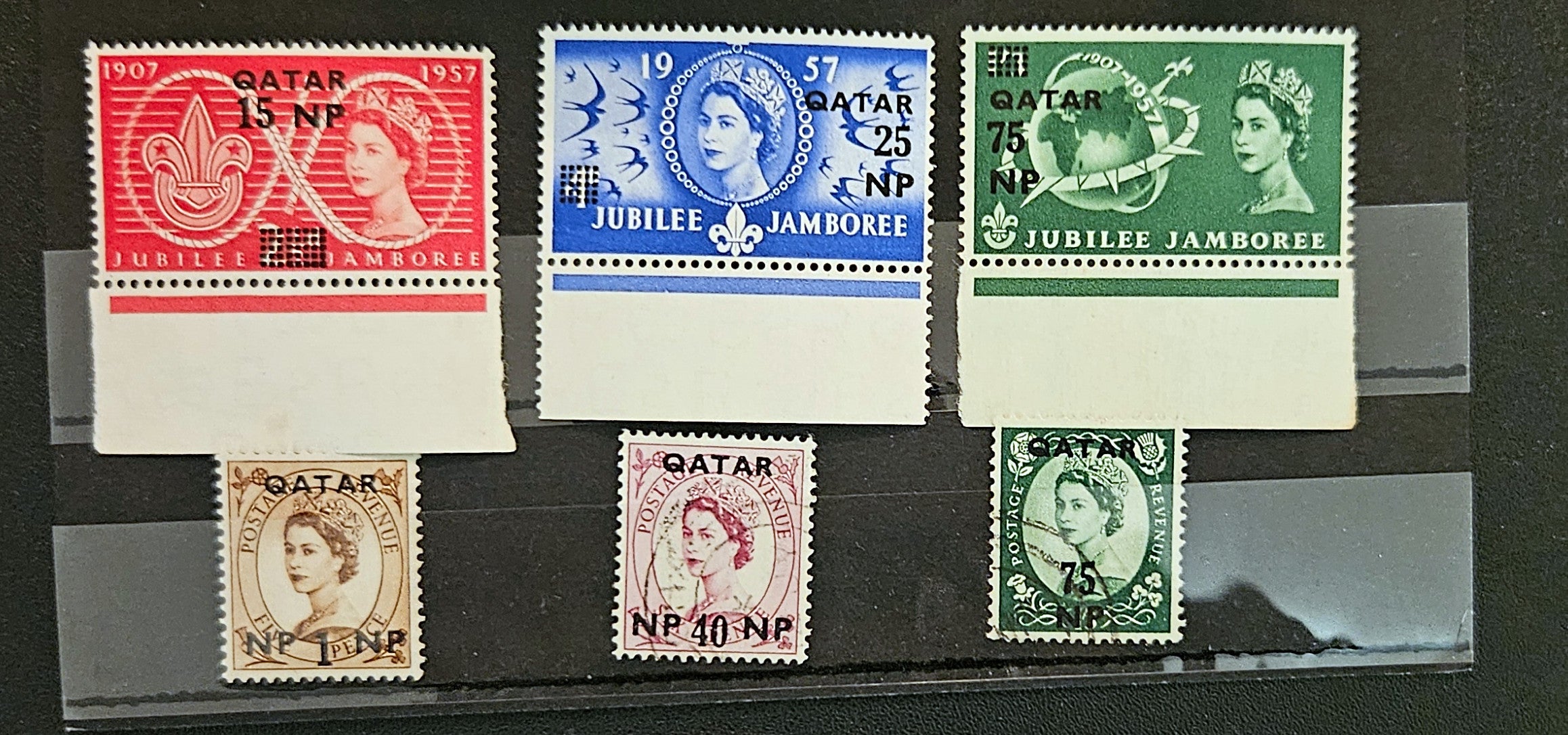 Collection of vintage stamps featuring Queen Elizabeth II on a dark background