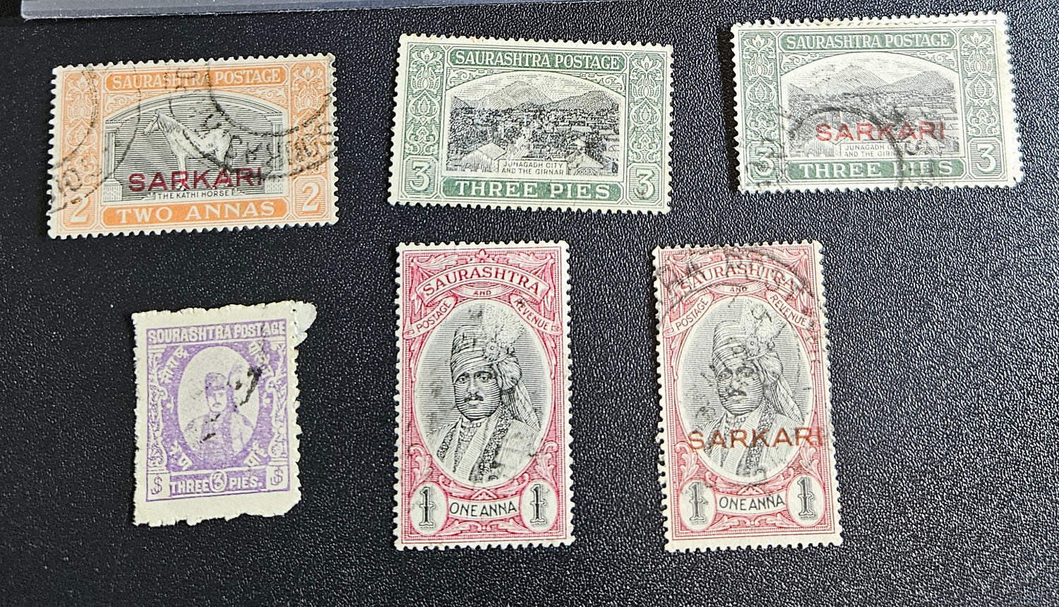 A collection of vintage Indian stamps from various feudatory states including Jhind, Bhopal, Saurashtra, Hyderabad, and Holkar, displayed on a flat surface.