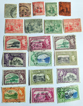 A collection of vintage Trinidad and Tobago stamps from the British Commonwealth era, displaying various colors and designs with historical and cultural themes.