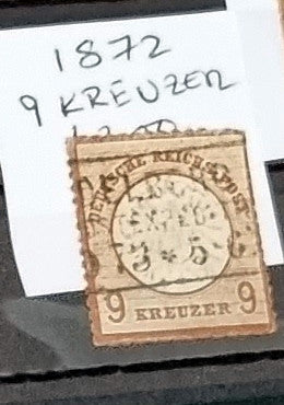 A vintage German stamp from 1872 with a 9 Kreuzer denomination, showing signs of wear and aging.