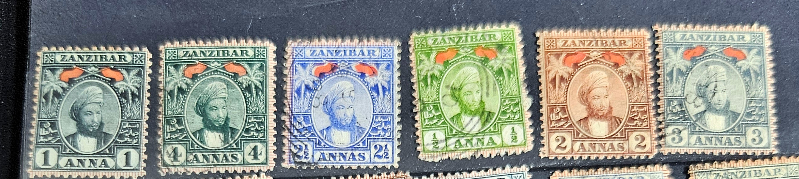 A collection of vintage Zanzibar stamps with various colors and designs, displayed horizontally.