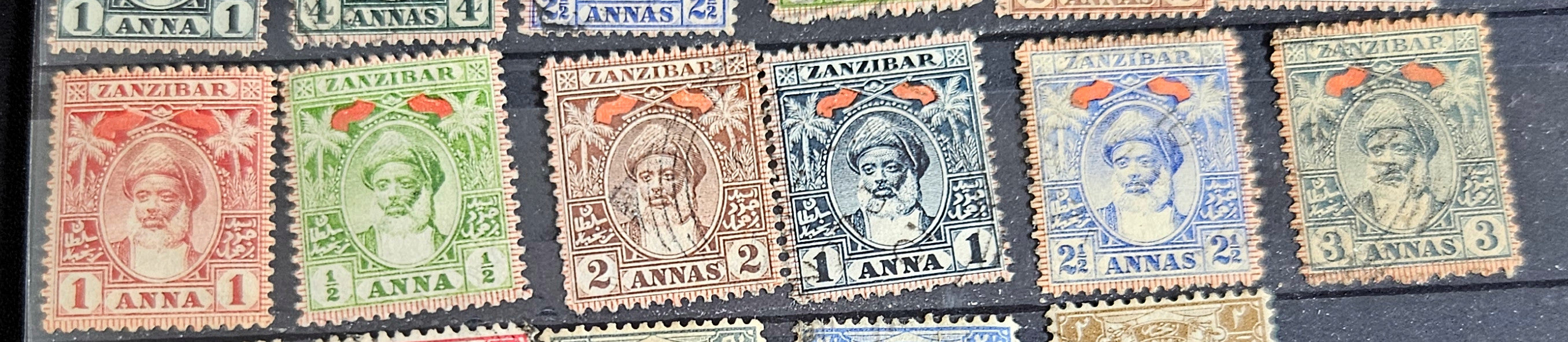 A collection of vintage Zanzibar stamps with various colors and designs, displayed horizontally.