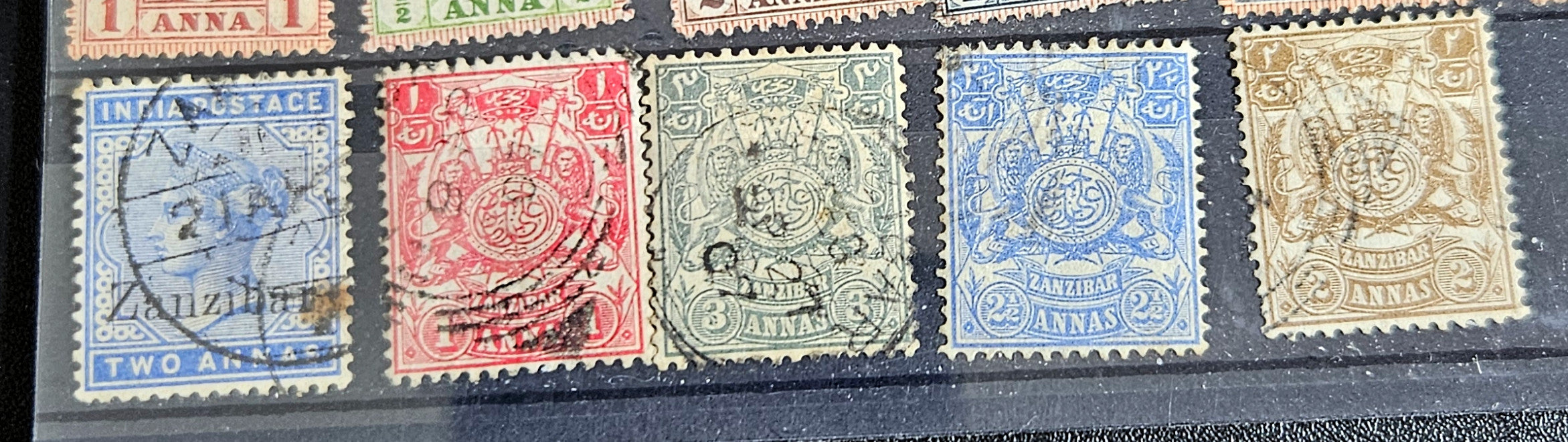A collection of vintage Zanzibar stamps with various colors and designs, displayed horizontally.