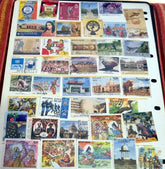 A collection of various Indian postage stamps displayed in a fanned out arrangement, showcasing different colors and designs with various images, including historical figures and national symbols.