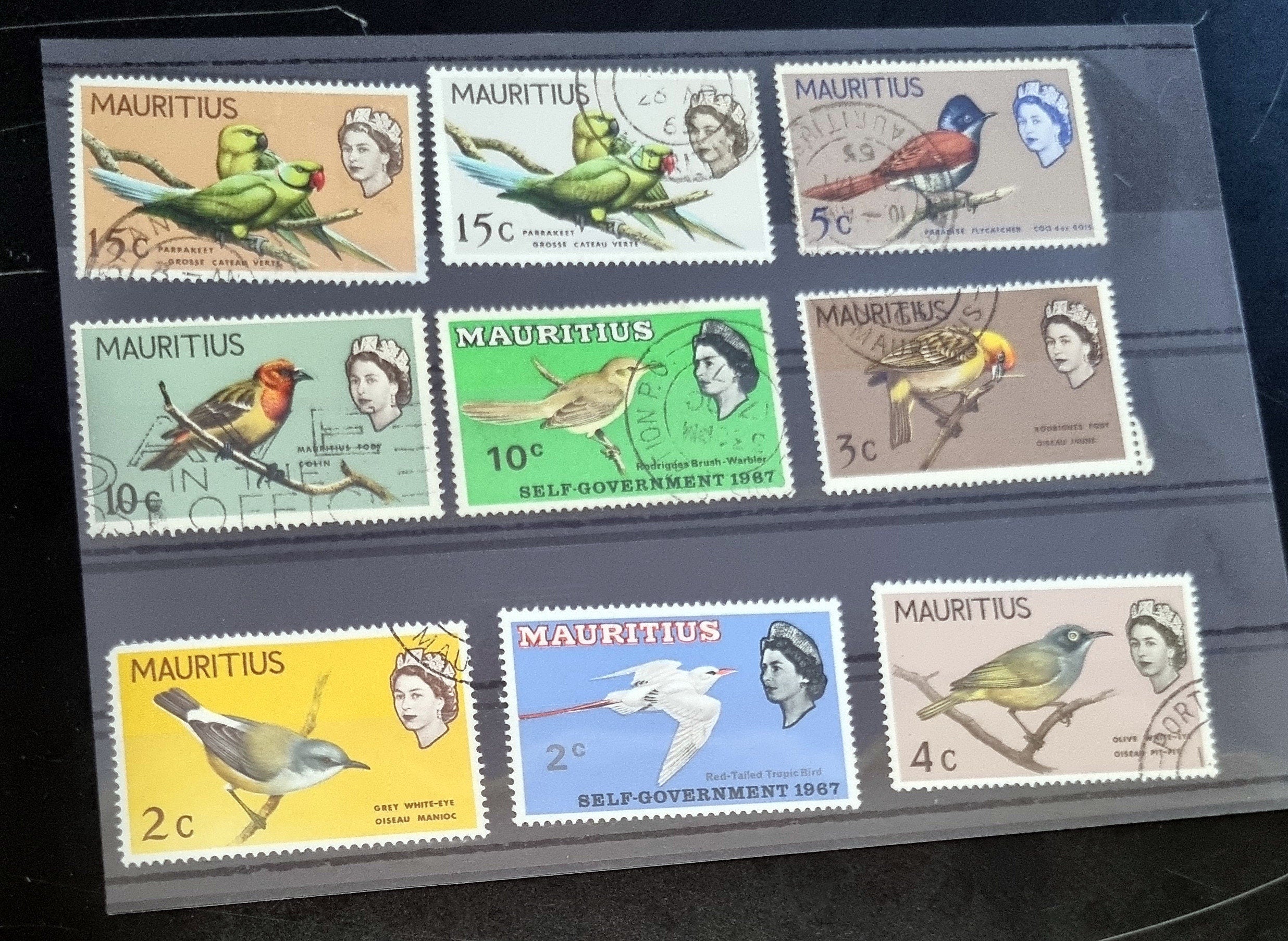 A collection of vintage postage stamps from Mauritius displayed in a row, featuring various designs and denominations.