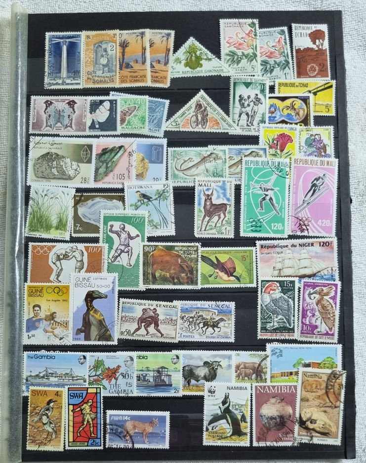 A collection of various postage stamps featuring different designs and colors, arranged in no specific order on a black background.