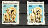 Two postage stamps featuring illustrations of individuals in traditional Burmese attire. One stamp is blue with a depiction of a man and woman, and the other is a single portrait of a man wearing a conical hat.