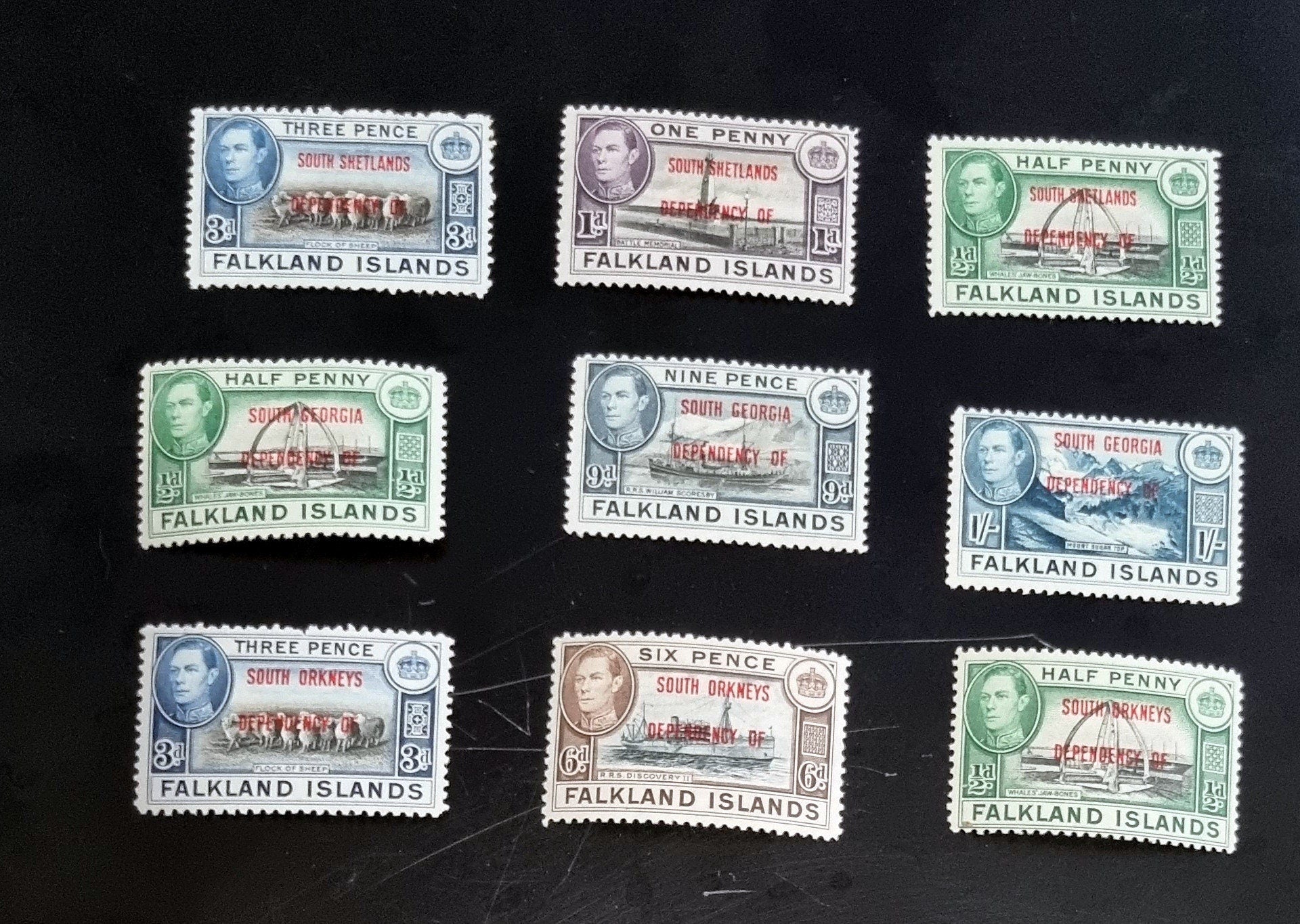 A set of vintage Falkland Islands stamps from various reigns, displayed in a row.