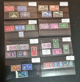 A collection of various commemorative postage stamps featuring Queen Elizabeth II, arranged in a clear plastic case with descriptive labels.