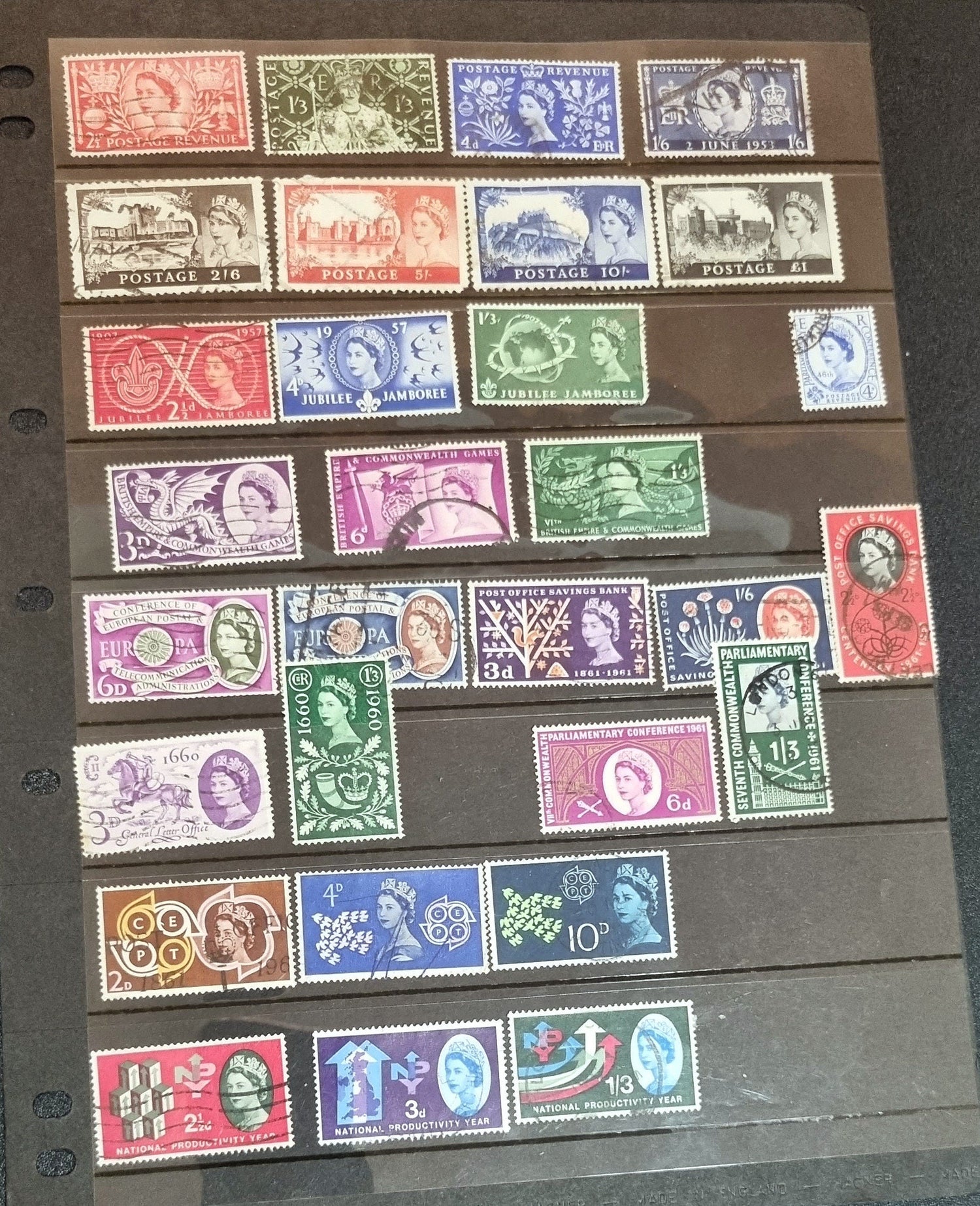 A collection of various commemorative postage stamps featuring Queen Elizabeth, arranged in a row, showcasing different colors and designs.